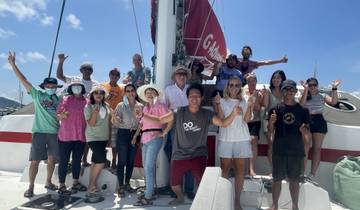 Group photo on a sailboat with clear skies.