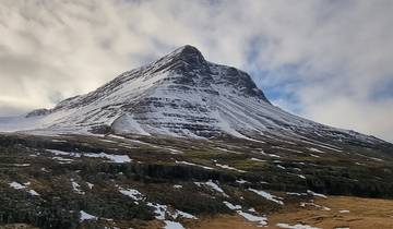 A snow-capped mountain under a cloudy sky.