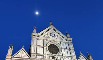 A grand church facade under a twilight sky with the moon.