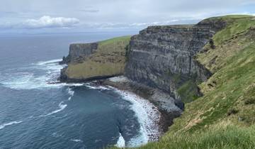 Aerial view of coastal cliffs with crashing waves below.
