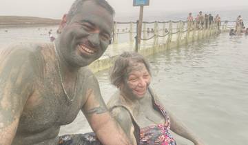 Two people covered in mud at a popular spa.