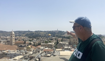 Man pointing towards the cityscape of Jerusalem.