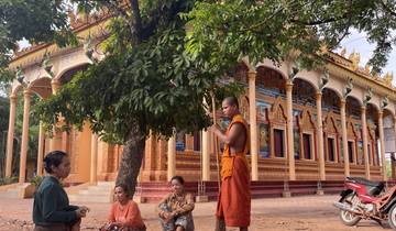 Monk and people outside decorative temple.