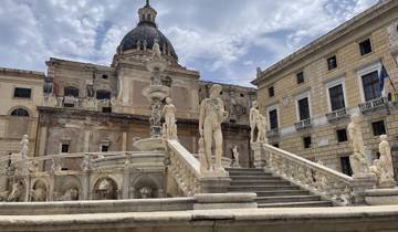 Magnificent historical fountain with statues in front of a grand building.