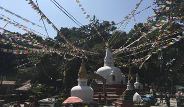 Stupas with prayer flags streaming over them.