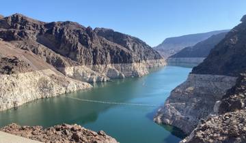 A river flowing through a canyon with mountains in the background.