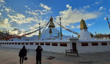 White stupa with prayer flags in a square.