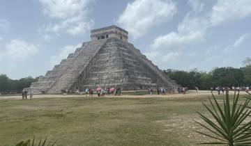 A large step pyramid with tourists at its base.