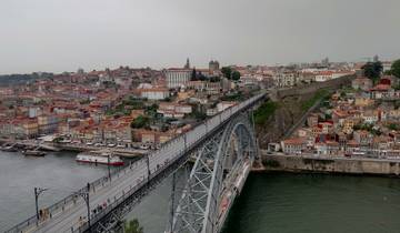 A cityscape of Porto, Portugal with the Dom Luís I Bridge over the river.