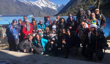 A group of hikers posing with snowy mountains in the background.
