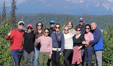 Group of people posing in front of mountains in the background.