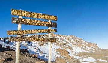 Sign at the summit of Mount Kilimanjaro with snow around.