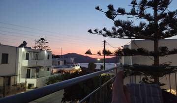 View of sunset from a balcony with modern buildings.