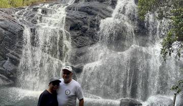 A couple standing in front of a waterfall.