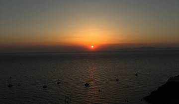 Stunning sunset over the ocean with silhouettes of boats.