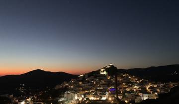 Evening view of a town on a hillside under a clear sky.