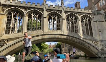 Group enjoying a boat tour under a historic stone bridge.
