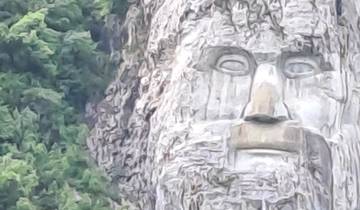 A large rock sculpture of a face in the mountainside.