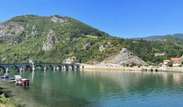 Scenic view of a bridge crossing a river with mountains