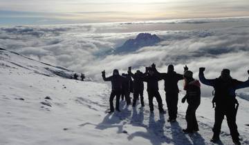 Group of hikers on a snowy mountain with stunning cloud views.
