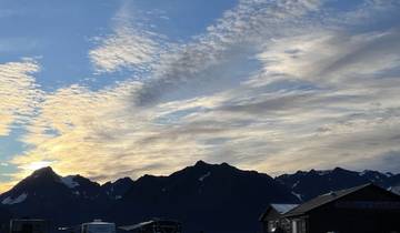 Silhouette of mountains with a cloudy sky during sunset.