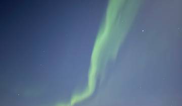 Northern lights in the night sky over a snowy landscape.