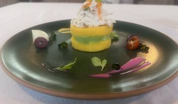 Artfully plated dish with layers of potato and avocado.
