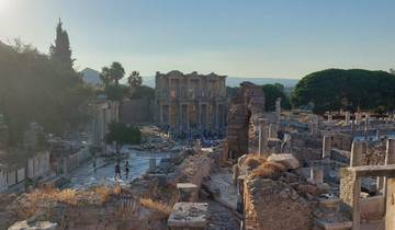 Ancient ruins with trees and people in the background.