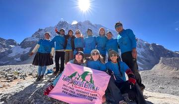 Group of hikers celebrating with a banner in the mountains.