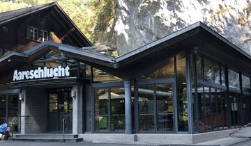 Modern building named Aareschlucht, set against rocky hillside.