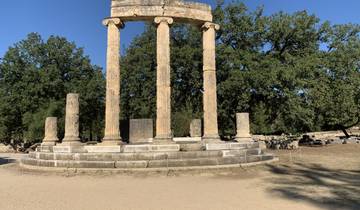 Ruins of ancient Greek columns and structures in an archaeological site.
