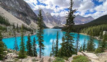 Turquoise lake surrounded by mountains and pine trees.