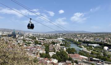 Cityscape with cable cars and a river running through.