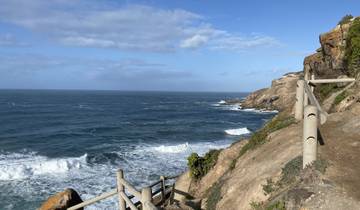 Coastal walkway with ocean view and clear skies.