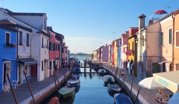 Colorful buildings lining a canal with boats in a sunny setting.