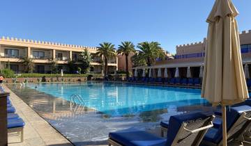 Luxurious poolside with lounge chairs and umbrellas.