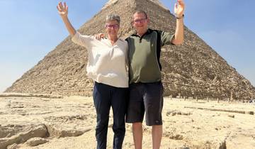Couple posing in front of a pyramid.