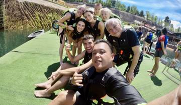 Group of people wearing life jackets posing on dock.