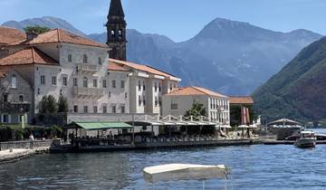 Picturesque waterfront architecture with mountain backdrop.