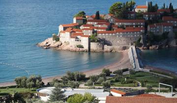 Aerial view of a small island with historic buildings connected by a causeway.