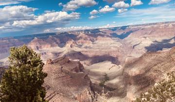 Panoramic view of the Grand Canyon under a partly cloudy sky.