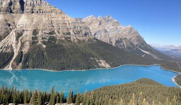 Wide view of a turquoise lake surrounded by mountains.