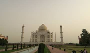 Taj Mahal with visitors in the foreground under a clear sky.