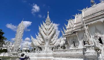Intricate white temple with ornate details and a clear blue sky.