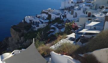 Cliffside view of white buildings and blue sea.