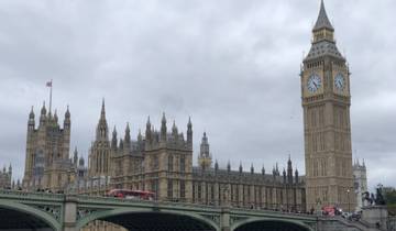 View of the Houses of Parliament and Big Ben with red bus crossing a bridge.