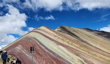 Colorful Rainbow Mountain landscape under a bright blue sky.