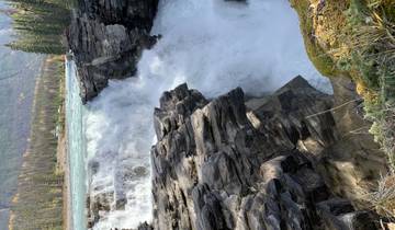 Waterfall amidst rocks in a forested area.