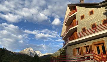Scenic view of a mountain with a building and blue sky