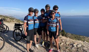 Group of cyclists posing with scenic coastline